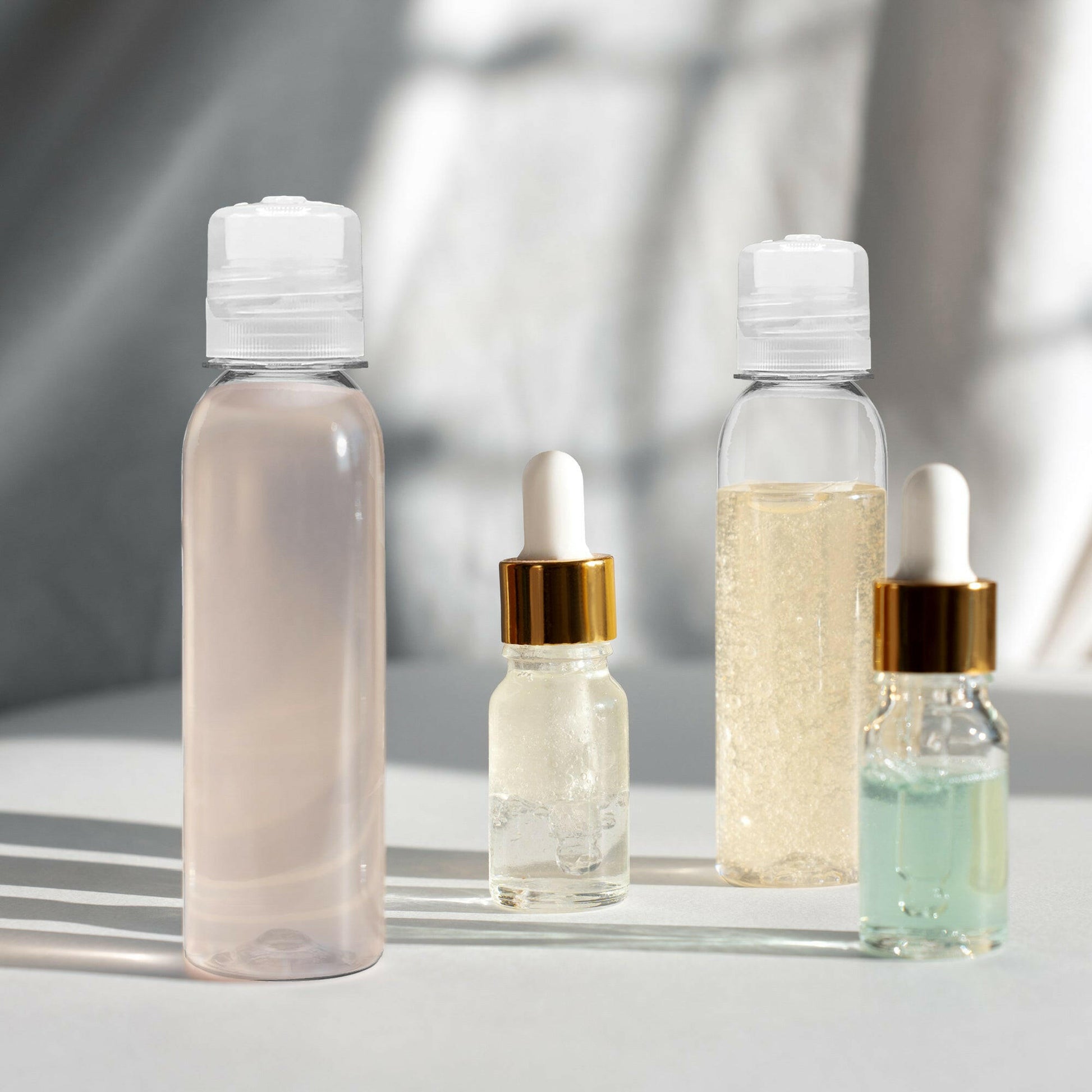 2 bottles of 4 oz Clear PET Cosmo Plastic Bottle with Clear Twist Top Cap. one with pink gel the other with pure aloe gel