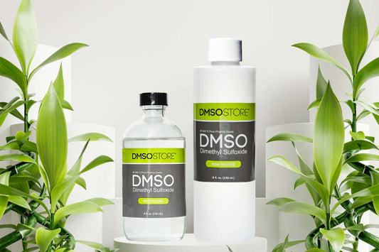 Two bottles of DMSO (Dimethyl Sulfoxide) Glass & BPA-Free Plastic from DMSOSTORE surrounded by green plants