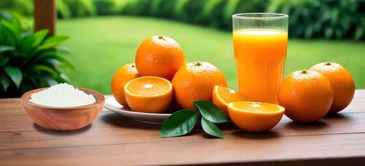 Fresh oranges with orange juice, bowl of L-Ascorbic Acid on a wooden table against a green garden background.