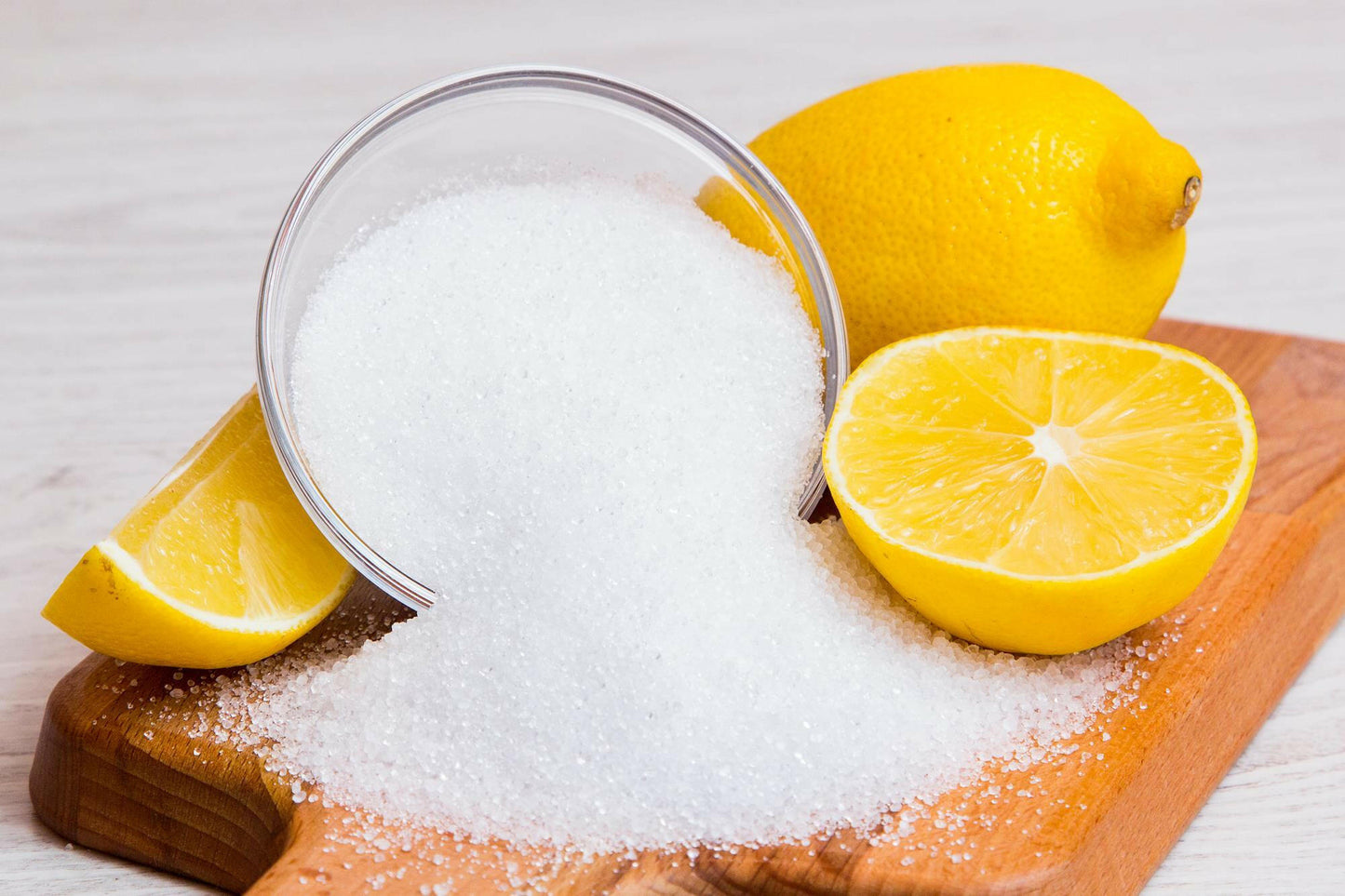 Sliced orange with citric acid powder on a cutting board.