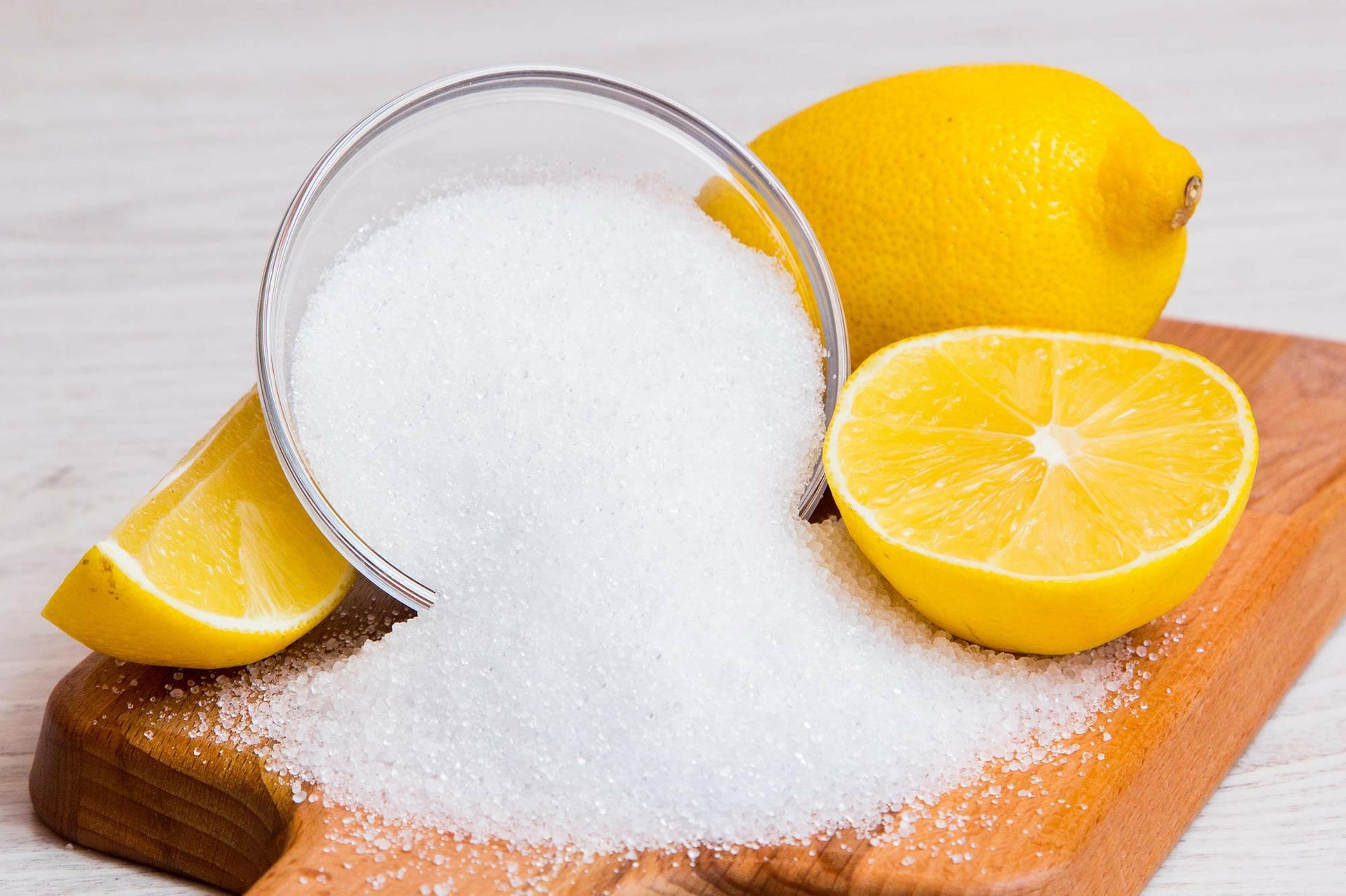 Sliced orange with citric acid powder on a cutting board.