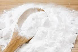 sodium benzoate powder on a wooden spoon