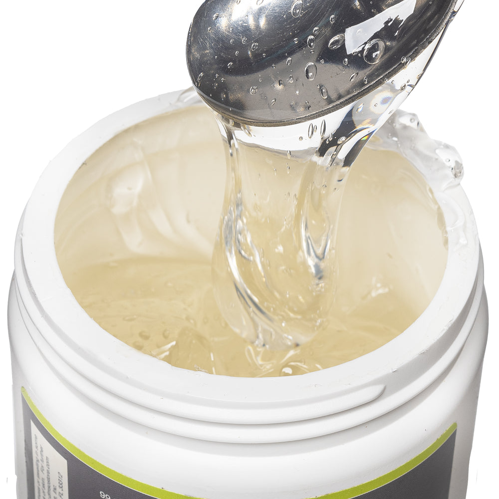 DMSO-gel-99.995-pure-dimethyl-sulfoxide-natural-pain-relief-scooped. Opened view of the 4 oz medi gel jar. Contents revealed is the medi gel product. Product is being scooped upwards with a spoon to show consistency.