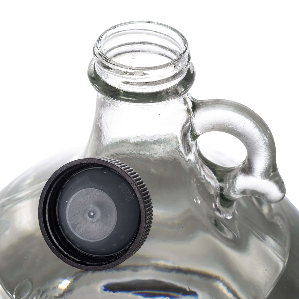 DMSO-liquid-99.995-gallon-organic-pain-relief-dimethyl-sulfoxide. one gallon glass jugs with handle. Black twist on cap detached to the jug.