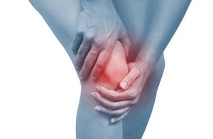 a knee with someone holding it b/c it is in hurt, they are looking for relief for pain