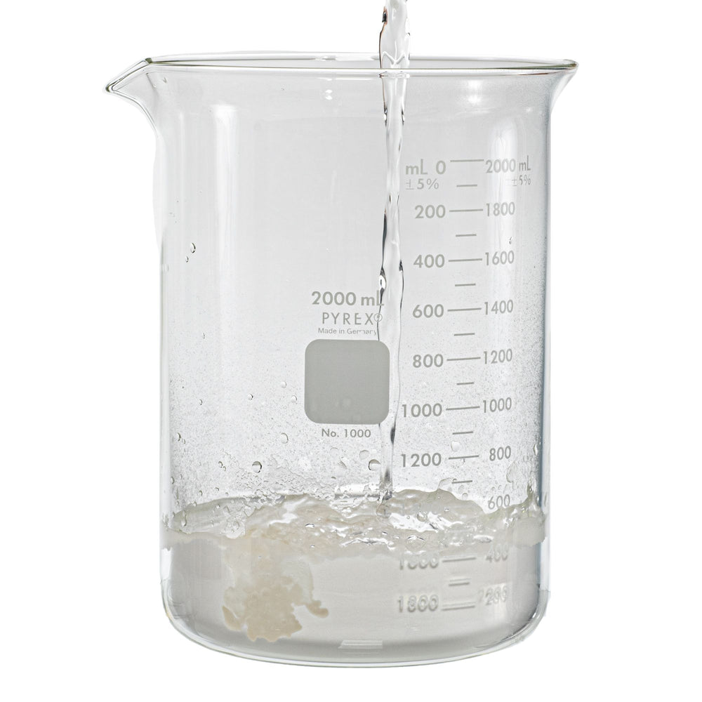 water being poured into a 2000 milliliter glass beaker. Beaker contains the sodium polyacrylate product.